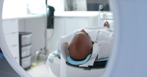 Senior african american man undergoing ct scan on hospital scanner for diagnostic imaging