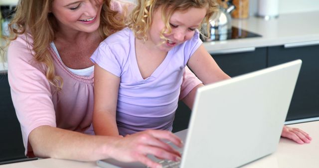 Mother and Daughter Bonding During Computer Time in Modern Kitchen - Download Free Stock Images Pikwizard.com