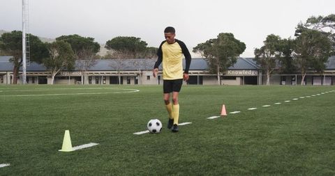 Teenage athlete practicing dribbling skills on soccer field