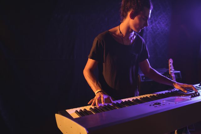 Confident male musician playing piano in nightclub