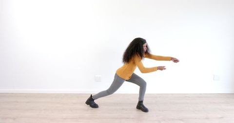 Dynamic Dance Movement by African American Woman in Mustard Sweater