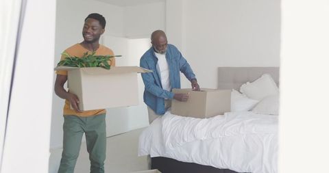 Father and son unboxing in bright modern bedroom