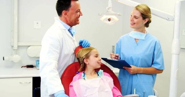 Female Dentist Assisting Male Dentist with a Young Patient in Dental Clinic - Download Free Stock Images Pikwizard.com