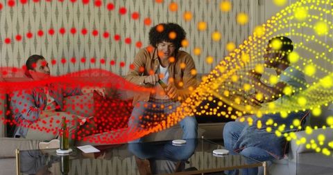 Three men relaxing on sofa popping bottle using laptop with colorful soundwave overlay