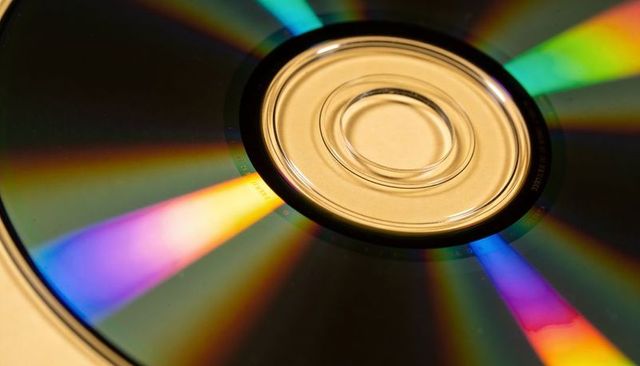 Compact disc reflecting vivid rainbow spectrum close-up with clear hub iridescence