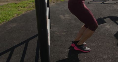 Caucasian woman exercising at outdoor gym seaside