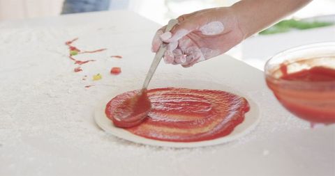 Homemade Pizza Preparation with Tomato Sauce