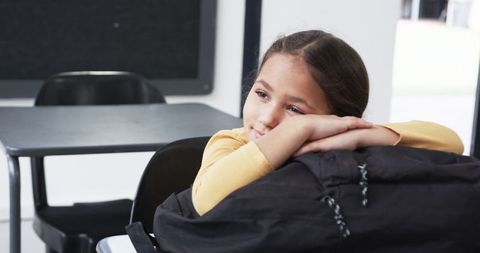 Thoughtful Schoolgirl Resting in Classroom