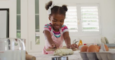 Happy Girl Enjoying Baking in Well-lit Kitchen