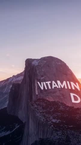 Vertical Dawn Footage Showing VITAMIN D Typography on Granite Monolith with Golden Sun Flare