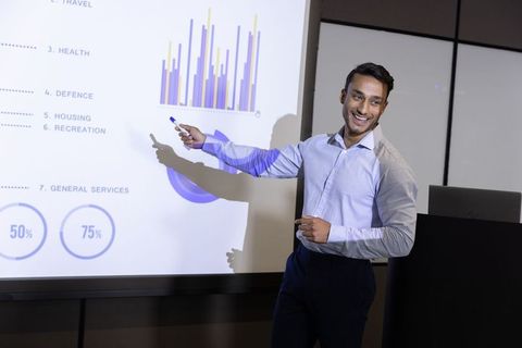 Confident Business Professional Analyzing Data on Projection Screen