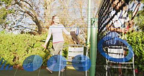 Friends practicing tennis on backyard court jumping near net with data overlay graphics