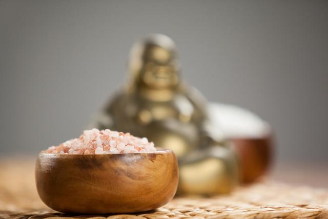 Laughing buddha figurine and sea salt in wooden bowl - Download Free Stock Photos Pikwizard.com