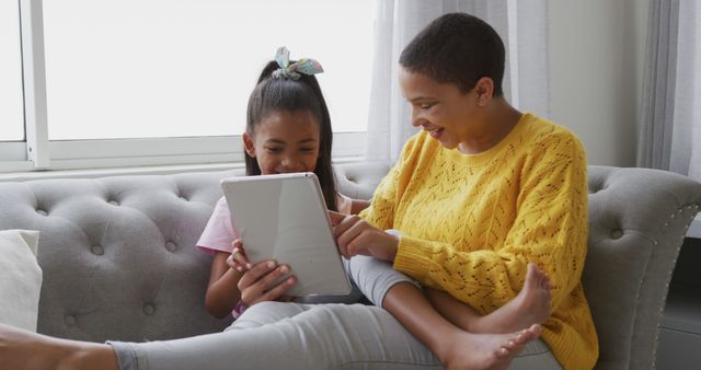 Mother and Daughter Using Digital Tablet on Couch - Download Free Stock Images Pikwizard.com