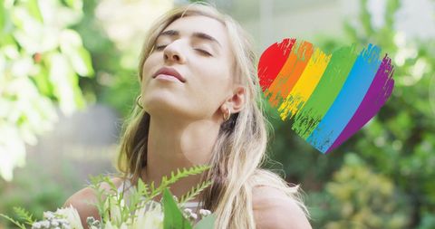 Woman in Wedding Dress with Rainbow Heart Emblem Relaxing Outdoors