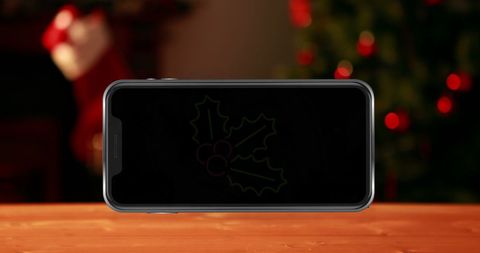 Smartphone Displaying Festive Leaves in Christmas Setting