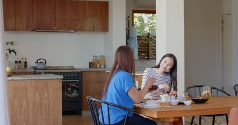 Mother and Daughter Enjoying Breakfast in Sunny Kitchen
