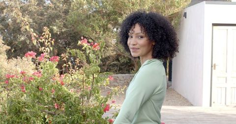 African American Woman Enjoying Garden Scenery in Modern Setting