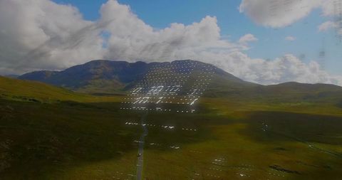 Serene Grassy Valley with Mountain Ridge and Roadway