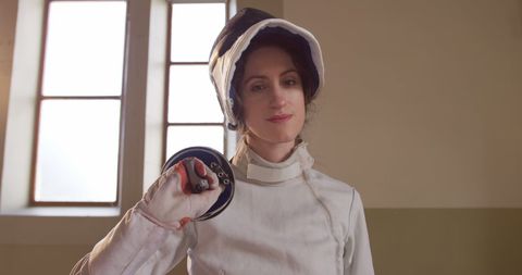 Female Fencer Holding Sword with Confidence in Training Room