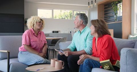 Senior Couple Chats with Young Woman in Cozy Living Room