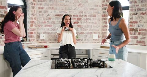 Joyful Friends Celebrating Pregnancy Announcement in Cozy Kitchen