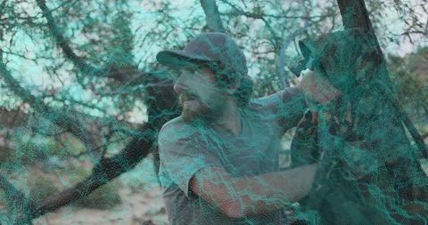 Adventurous Man Climbing in Wilderness Sporting a Cap