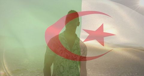 Backlit man on sunlit beach with algerian flag double exposure for travel and pride
