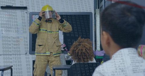 Firefighter demonstrating helmet and face shield to schoolchildren in classroom safety visit