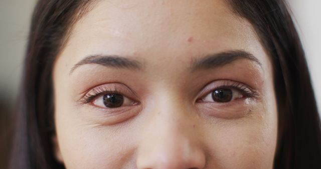 Close-up focus on young woman's eyes, showcasing natural beauty and expressiveness. Useful for beauty products, skincare ads, eye makeup promotions, emotional storytelling, or mental health awareness campaigns.