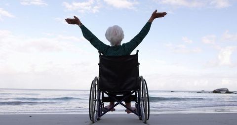 Joyful Elderly Woman in Wheelchair Enjoying Beach Serenity
