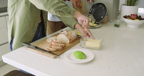 Diverse Couple Preparing Breakfast on Quartz Island Slicing Artisan Bread Spreading Butter