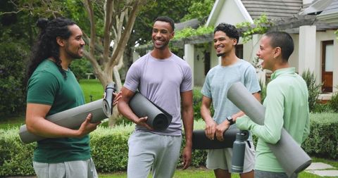 Friends Enjoying Outdoor Fitness Holding Yoga Mats and Water Bottle