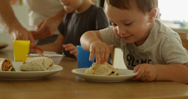 Young Children Eating Wraps During Family Meal Time - Download Free Stock Images Pikwizard.com