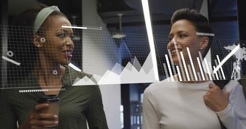 Walking colleagues discussing data with holographic charts in modern workspace