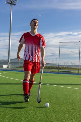 Male Field Hockey Player on Turf with Stick and Ball