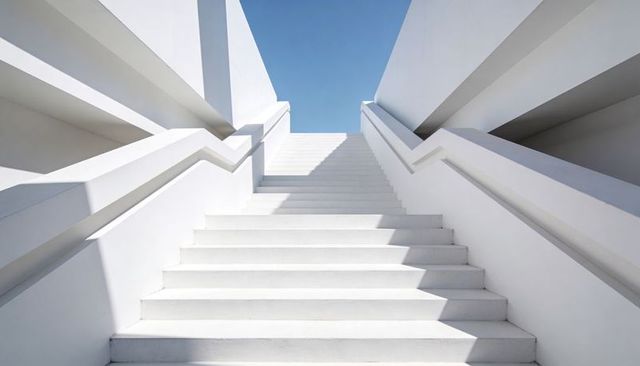 Minimalist White Staircase Rising into Blue Sky with Strong Geometric Lines and Shadows