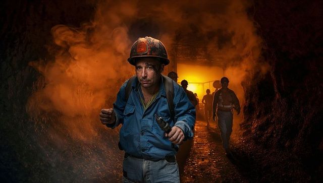 Dedicated Miner Walking Through Underground Tunnel with Tools