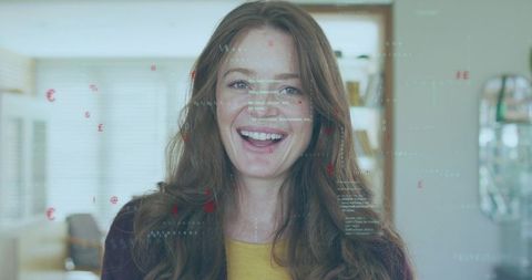 Smiling woman wearing mustard-yellow top and cardigan with digital data overlays in sunlit living ro