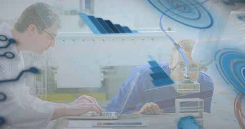 Engineers collaborating on robotic arm testing with laptop in industrial automation workshop