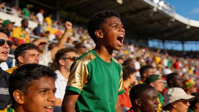 Teen fan cheering loudly in stadium standing among excited sports crowd during live match