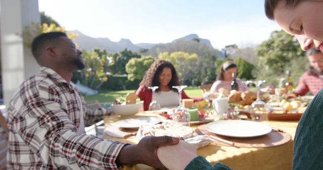 Diverse group of friends holding hands at outdoor dinner - Download Free Stock Images Pikwizard.com