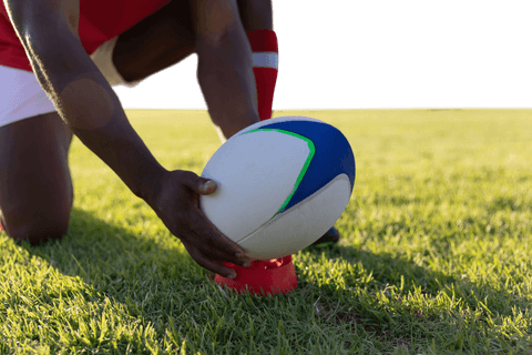 Mixed-race rugby player preparing to kick ball transparent background