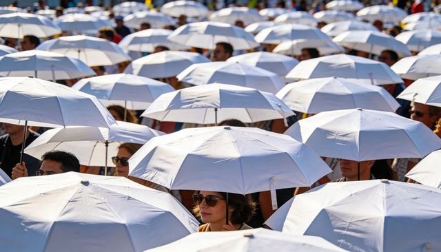 Crowd forming canopy of white umbrellas shielding faces from sun at outdoor gathering