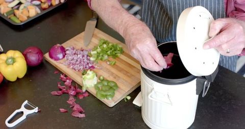 Senior Couple Composting Vegetable Peels at Home