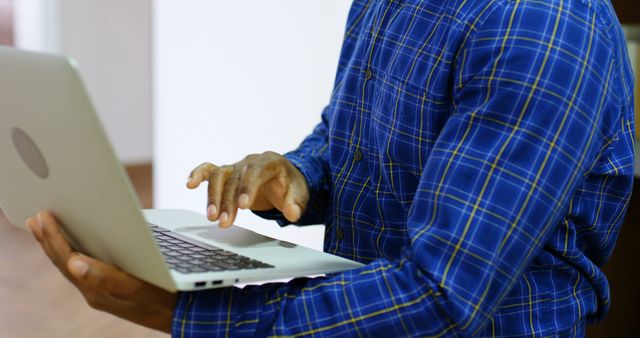 Focused Professional Working on Laptop in Office, Blue Plaid Shirt - Download Free Stock Images Pikwizard.com