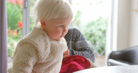 Curious toddler crawling on table in cozy home environment