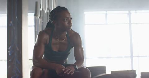 Athletic Woman Resting After Intense Workout in Gym Setting