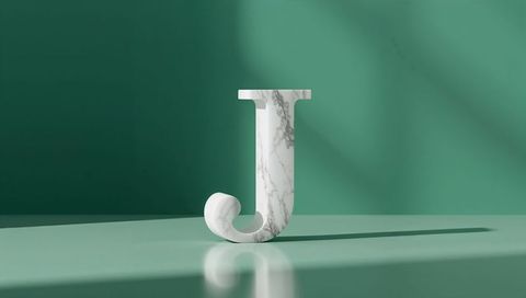Marble textured letter j on glossy green platform