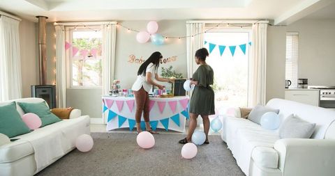 Friends Setting Baby Shower Party in Bright Living Room